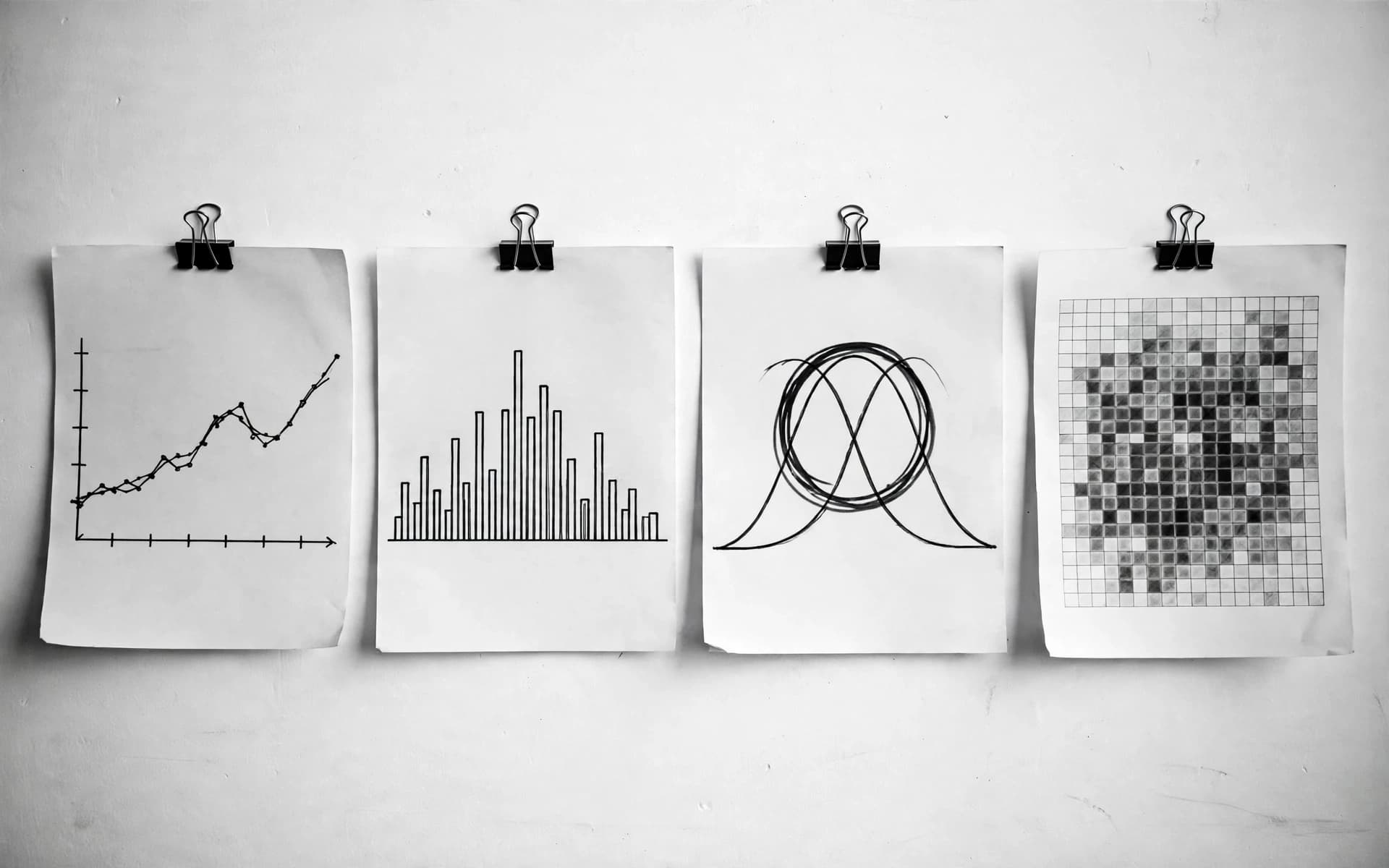 Dört klipslenmiş kâğıt: elle çizilmiş dağılım grafiği, histogram, keçeli kalemle çevrelenmiş normal dağılım eğrisi ve ısı haritası.